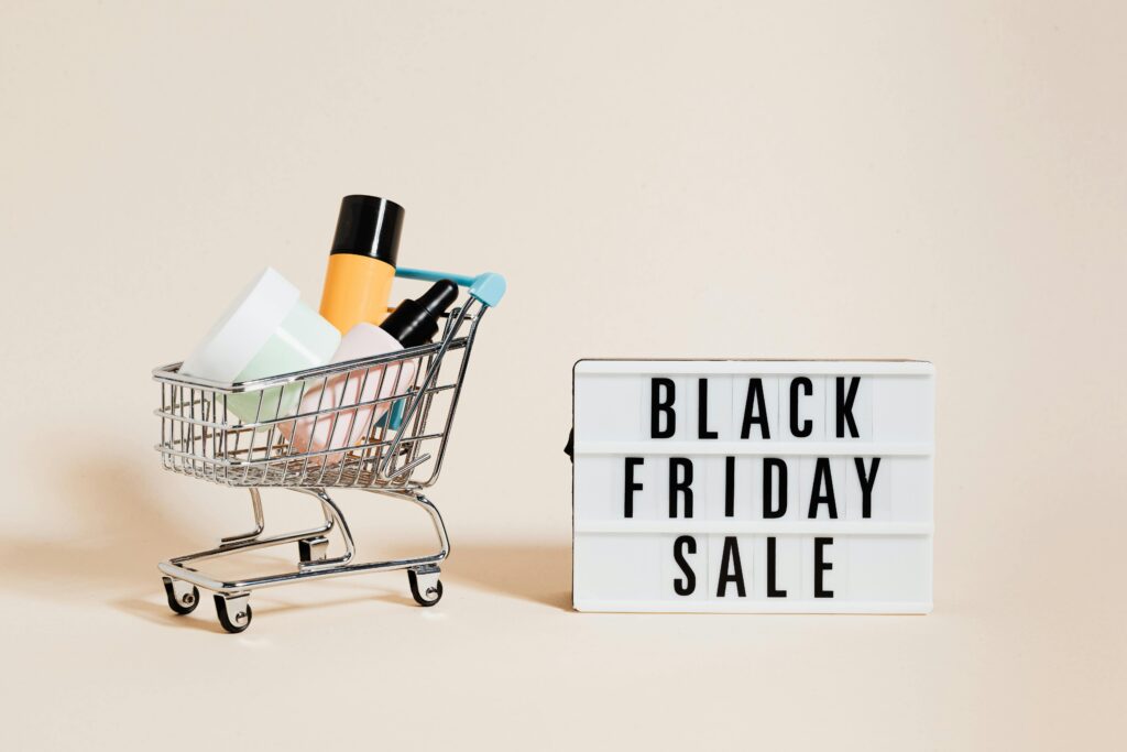 Stylish display of a mini shopping cart and a Black Friday sale sign on a beige background.